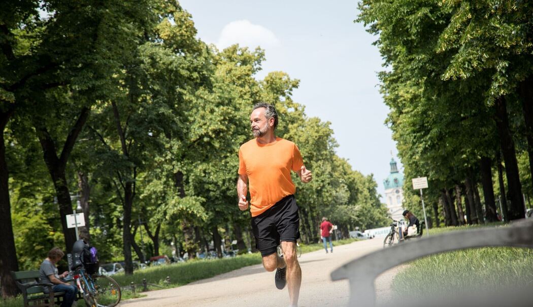 Ein Mann joggt durch einen Park