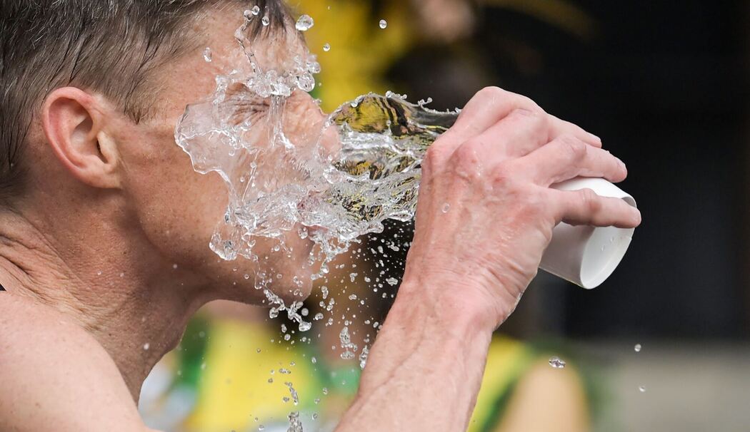 Ein Mann schüttet sich Wasser ins Gesicht