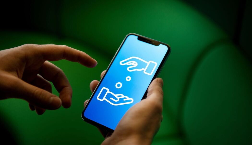 Ein Mann verwende ein Smartphone zum Geldverkehr