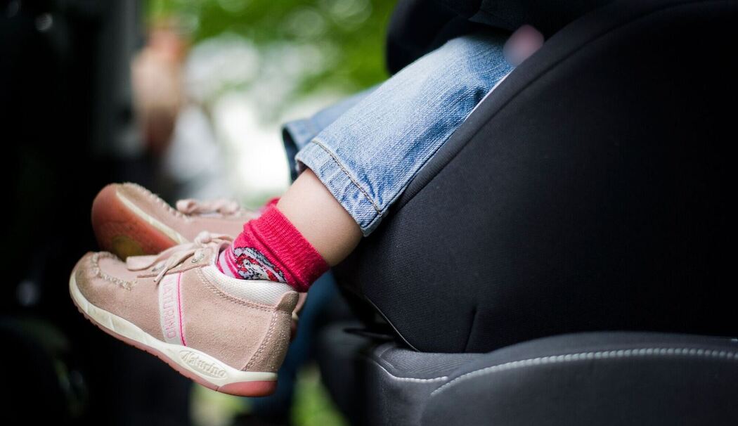 Mädchen sitzt in einem Kindersitz im Auto