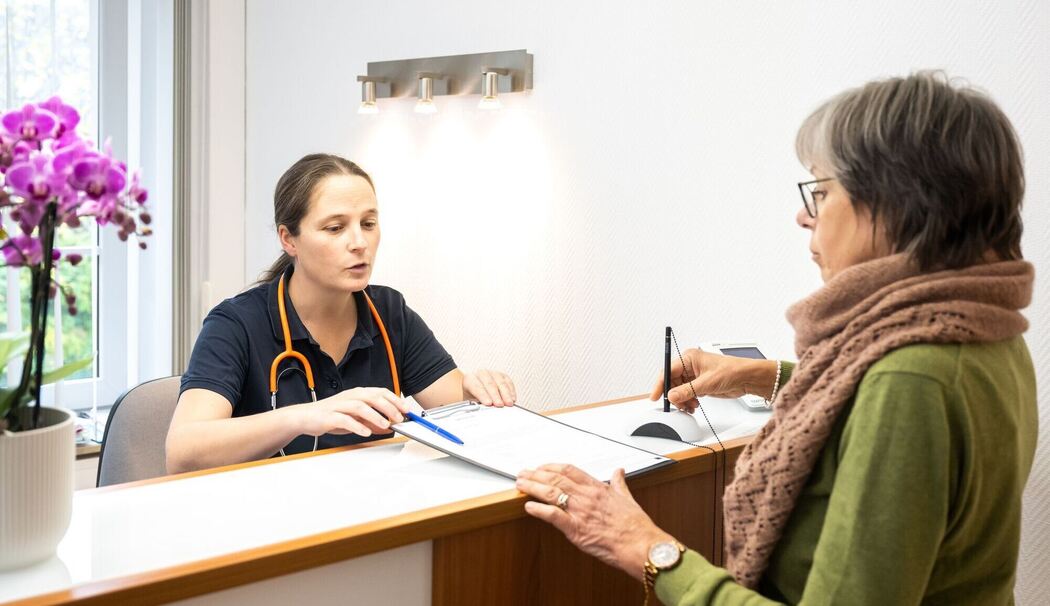 Eine Patientin wird von einer Sprechstundenhilfe beraten