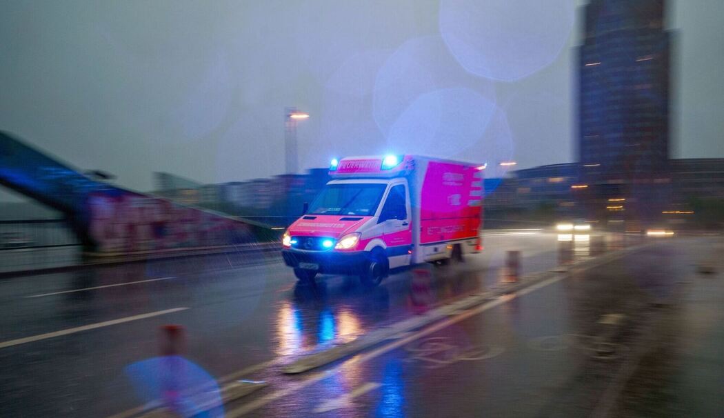 Ein Rettungswagen fährt bei Regen über eine Brücke