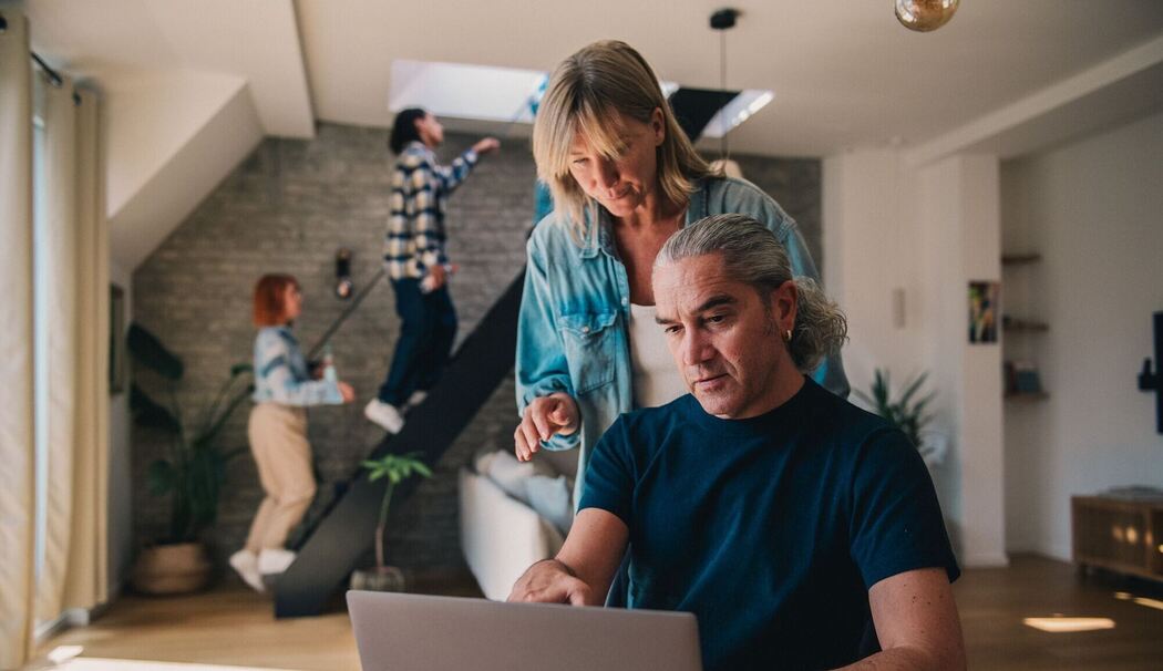 Ein Mann und eine Frau blicken auf einen Laptop