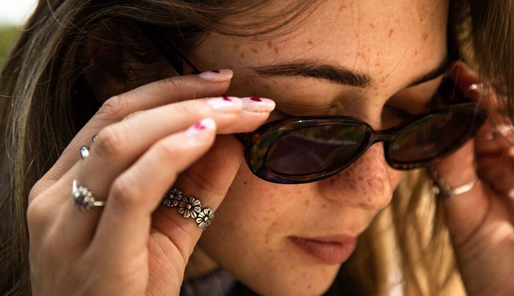 Eine Frau mit Sommersprossen und Sonnenbrille
