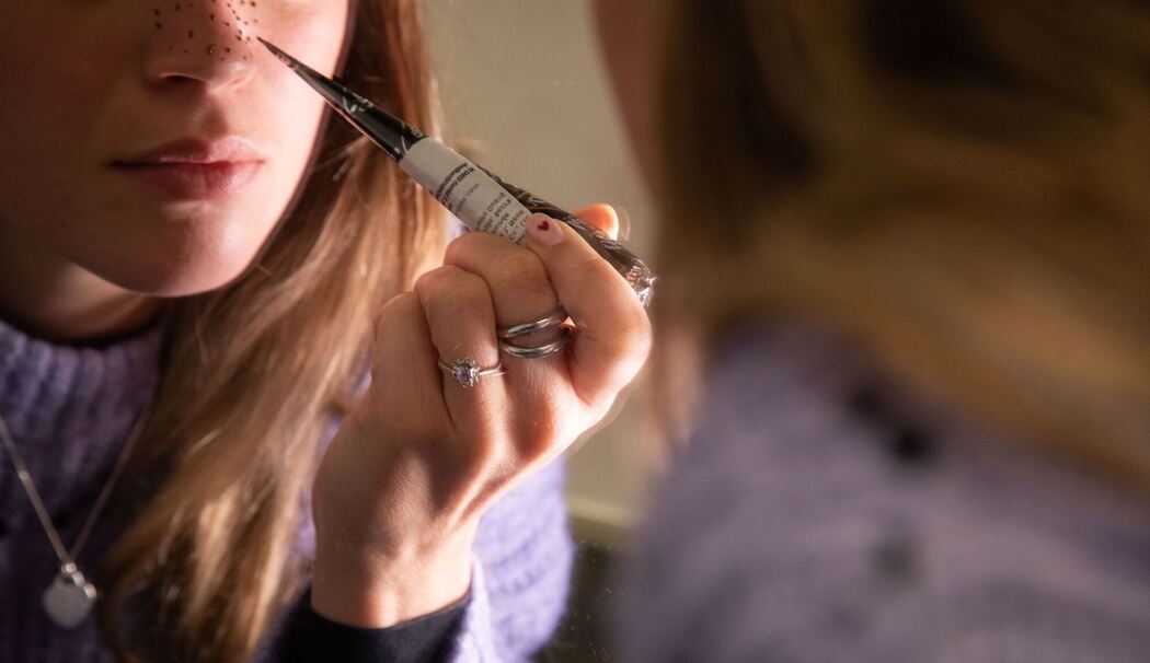 Eine Frau färbt sich Sommersprossen mit Henna