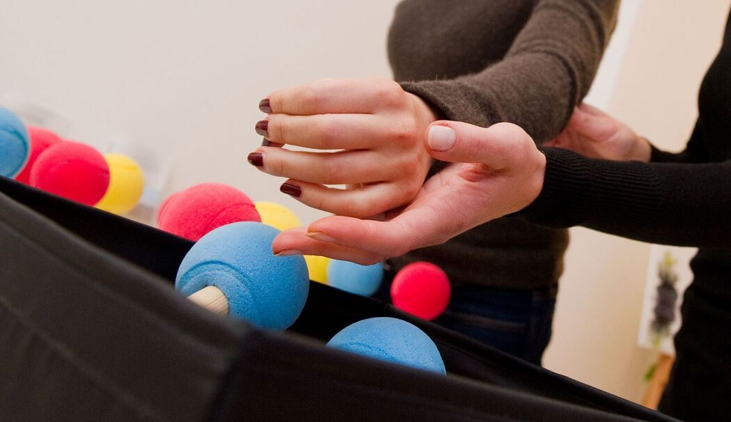 Frau trainiert bei einer Ergotherapie ihre Hand