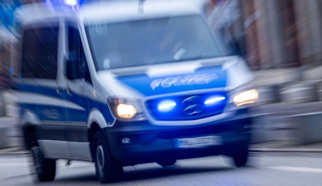 Einsatzfahrzeug der Polizei fährt mit Blaulicht durch Innenstadt