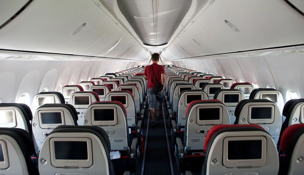 Mann geht durch den Gamg in einem Flugzeug