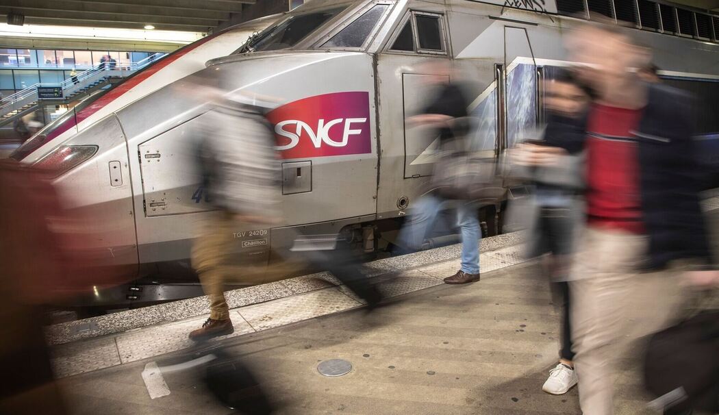 Reisende vor einem Zug des SNCF am Bahnhof Montparnasse
