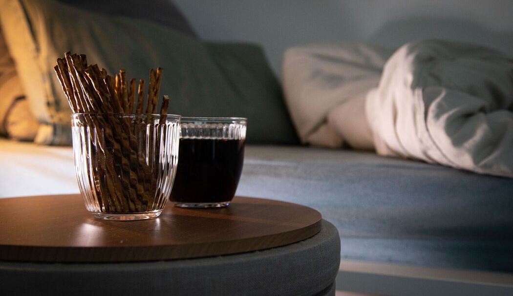 Aufgeschlagenes Bett mit Salzstangen und Cola