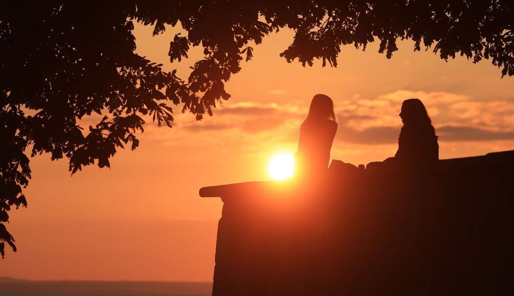 Zwei Frauen unterhalten sich bei Sonnenuntergang