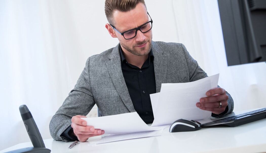 Ein Mann sieht im Büro in Unterlagen