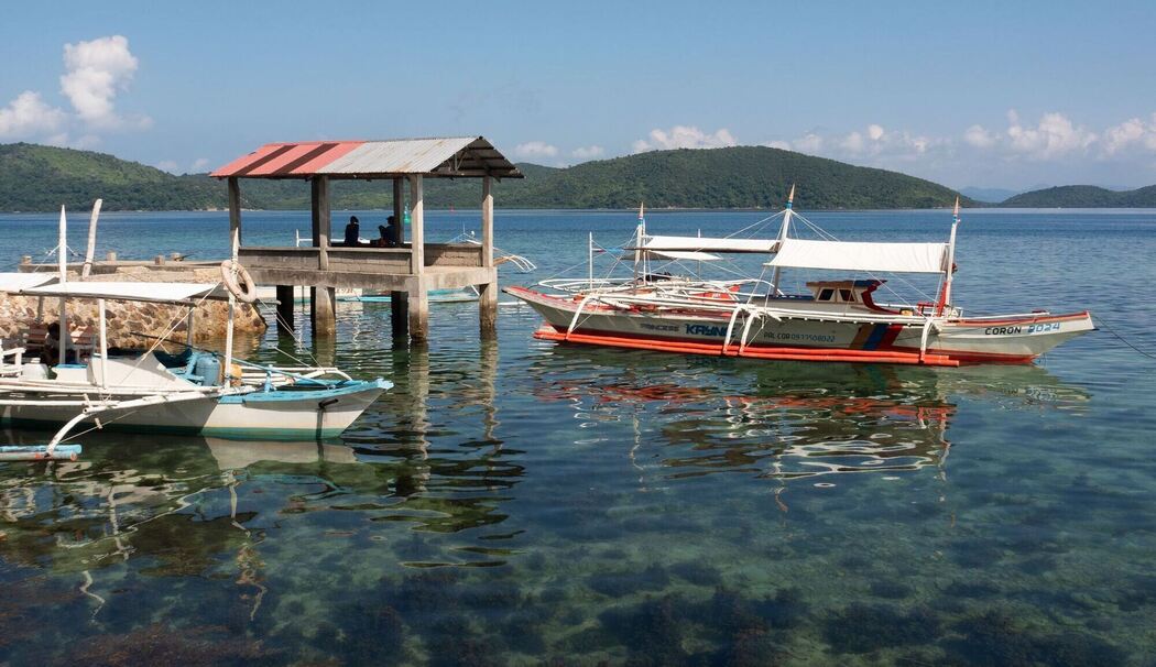 Boote liegen im Wasser vor Culion