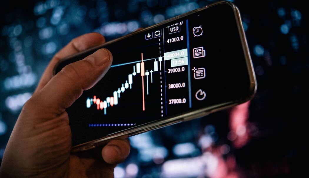Mann schaut sich AKtienkurse auf dem Smartphone an