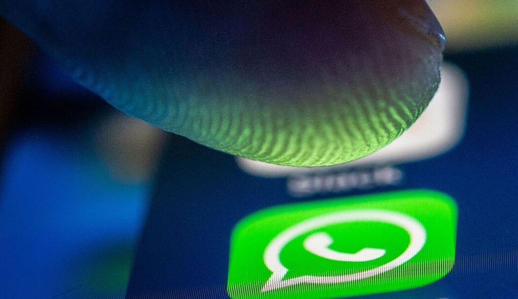 Ein Finger über dem Whatsapp Symbol