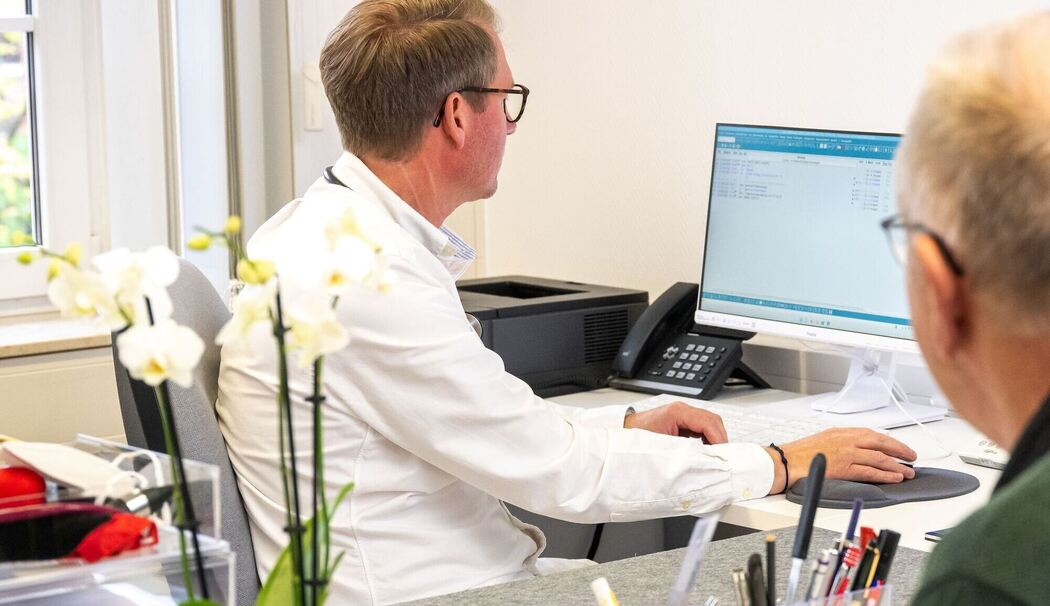 Arzt mit einem Patienten bei einer Sprechstunde