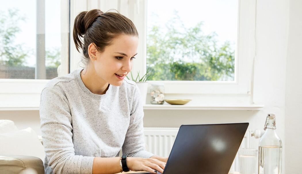 Eine junge Frau arbeitet an einem Laptop