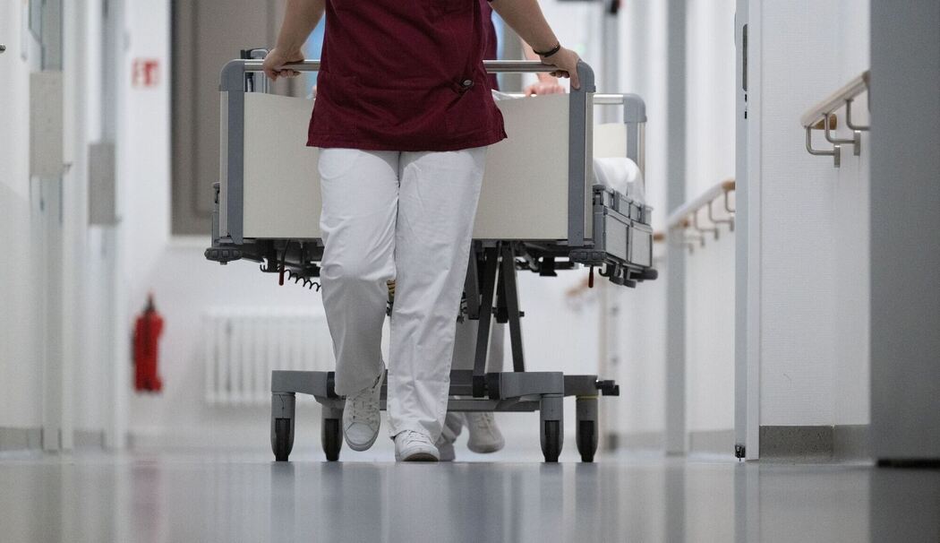 Zwei Krankenpfleger schieben ein Krankenbett