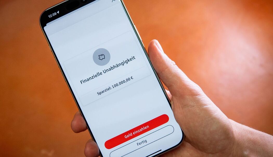 Eine Frau nutzt eine Handy-App zum Sparen