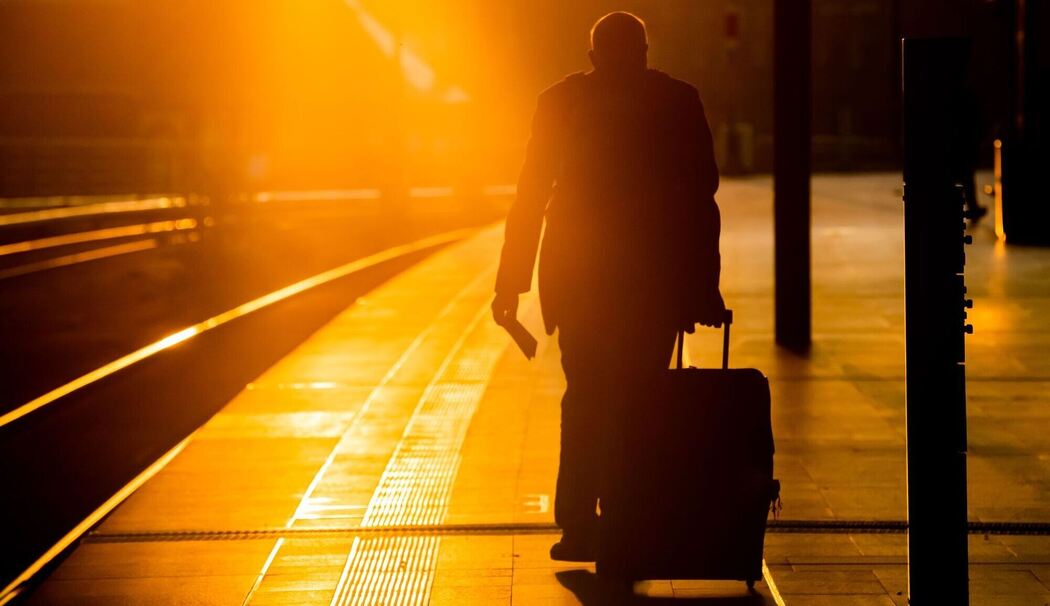 Mann geht über einen Bahnsteig
