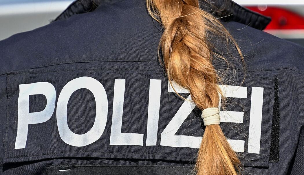 Der Zopf einer Polizistin hängt über ihre Uniform.