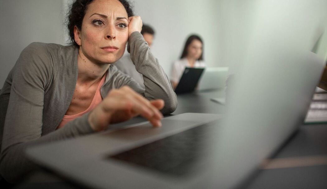 Frau sitzt frustriert vor einem Laptop