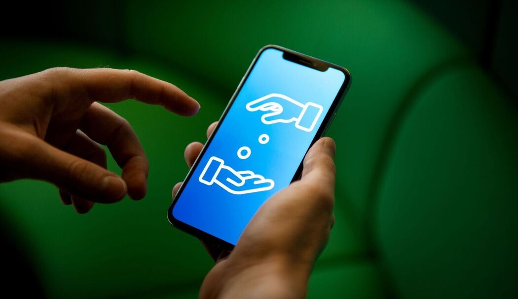 Ein Smartphone, auf dem Geldgeschäfte symbolisiert sind