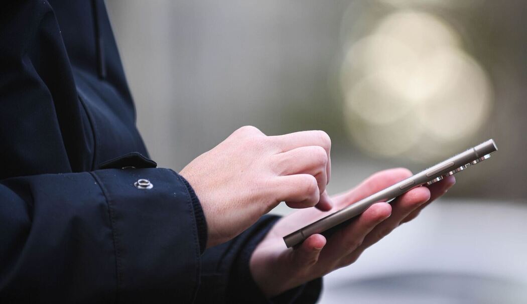 Frau tippt auf einem Smartphone