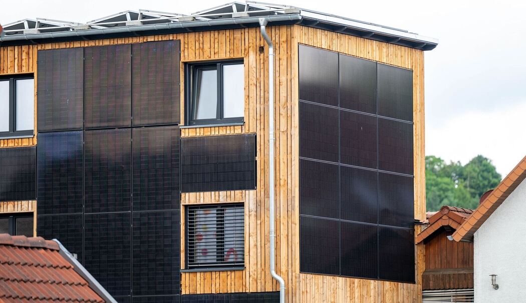 Eine Hauswand ist mit Solarpanels verkleidet