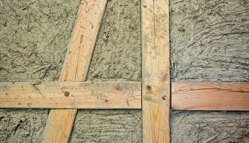 Eine nicht fertige Wand aus Fachwerk und Lehm