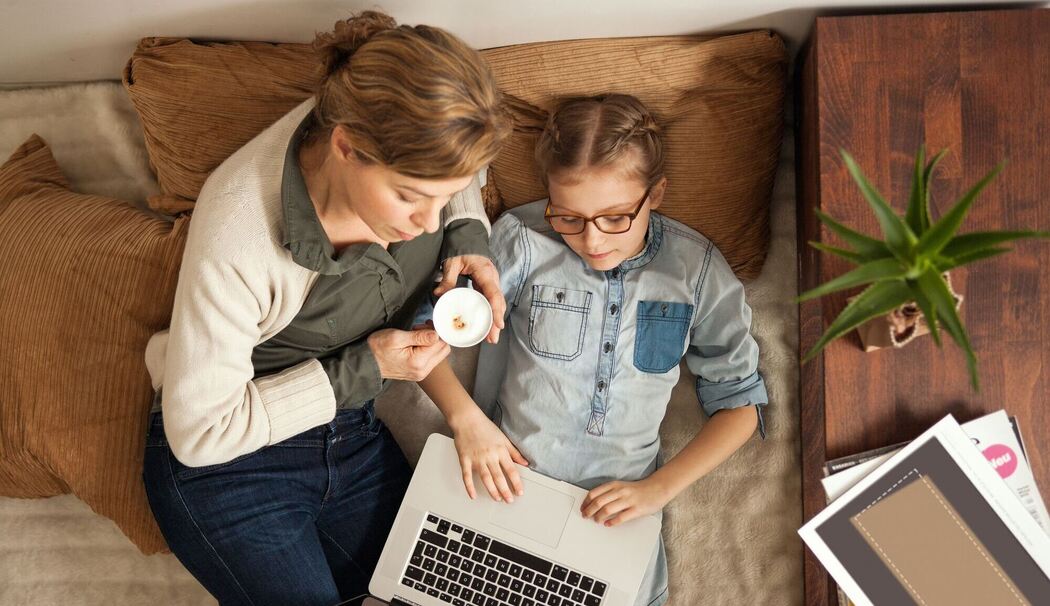 Mutter und Tochter schauen gemeinsam auf einen Laptop