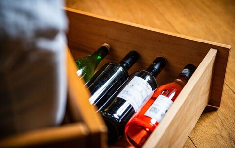 Weinflaschen liegen in einem Bettkasten