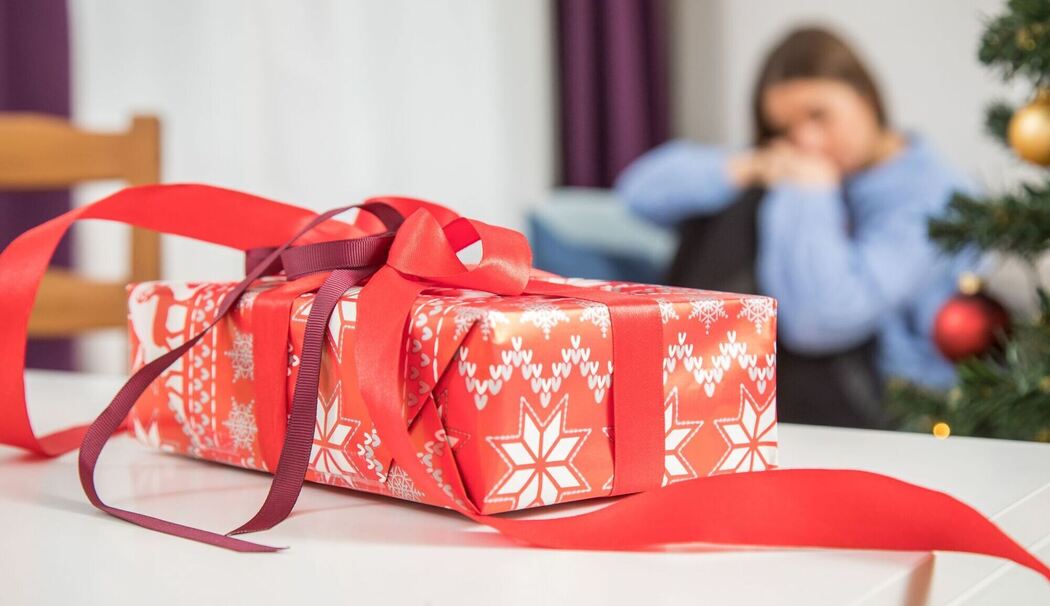 Ein Geschenk auf dem Tisch - eine Frau im Hintergrund