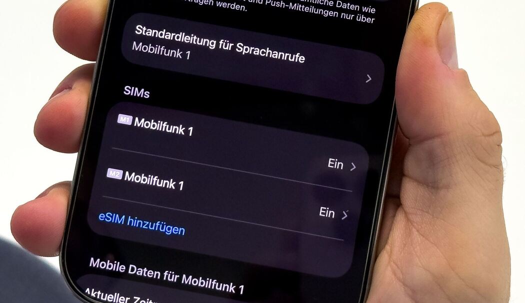 Ein Mann aendert die SIM-Karten-Einstellungen auf einem iPhone