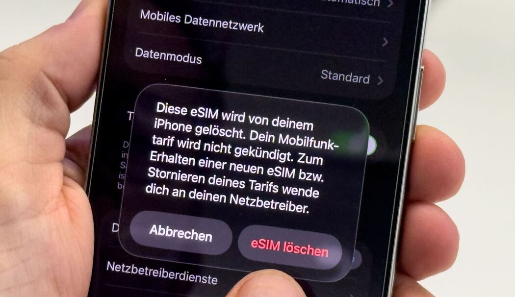 Ein Mann aendert die SIM-Karten-Einstellungen auf einem iPhone