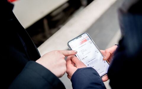 Zwei Personen bedienen die DB-App