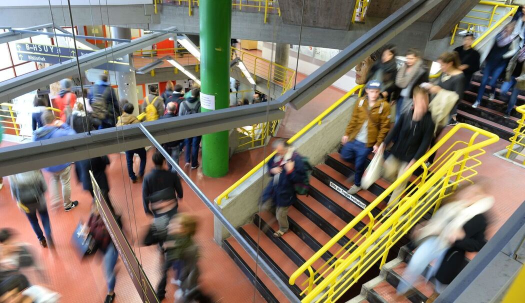 Studierende laufen durch das Treppenhaus einer Hochschule Studierende laufen durch das Treppenhaus einer Hochschule