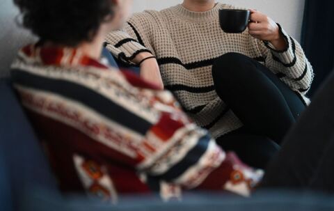 Zwei Frauen sitzen auf einem Sofa und unterhalten sich