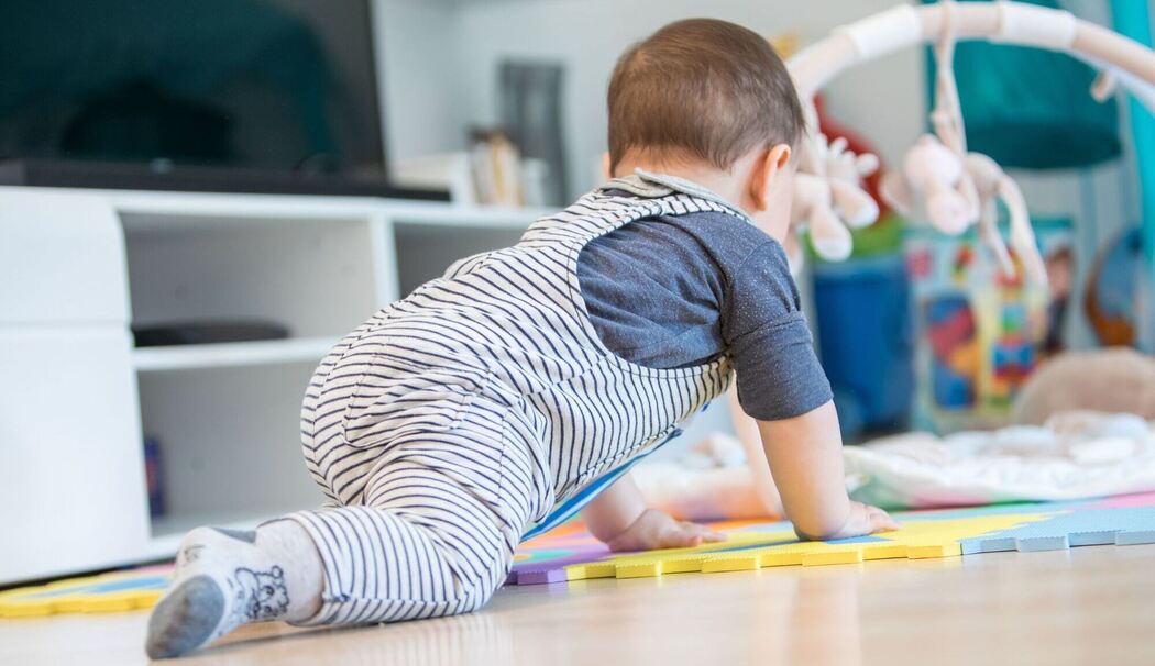Ein Baby krabbelt durch ein Zimmer