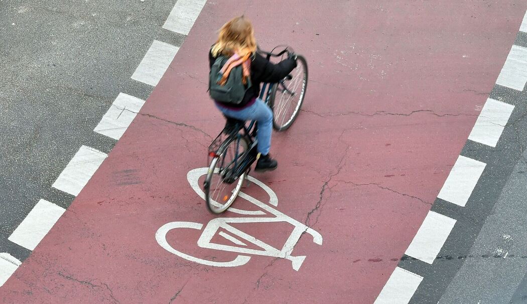Eine Frau fährt auf einem Fahrradstreifen in einem Kreisverkehr
