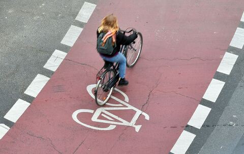 Eine Frau fährt auf einem Fahrradstreifen in einem Kreisverkehr