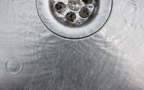 Wasser läuft in einen Abfluss im Spülbecken