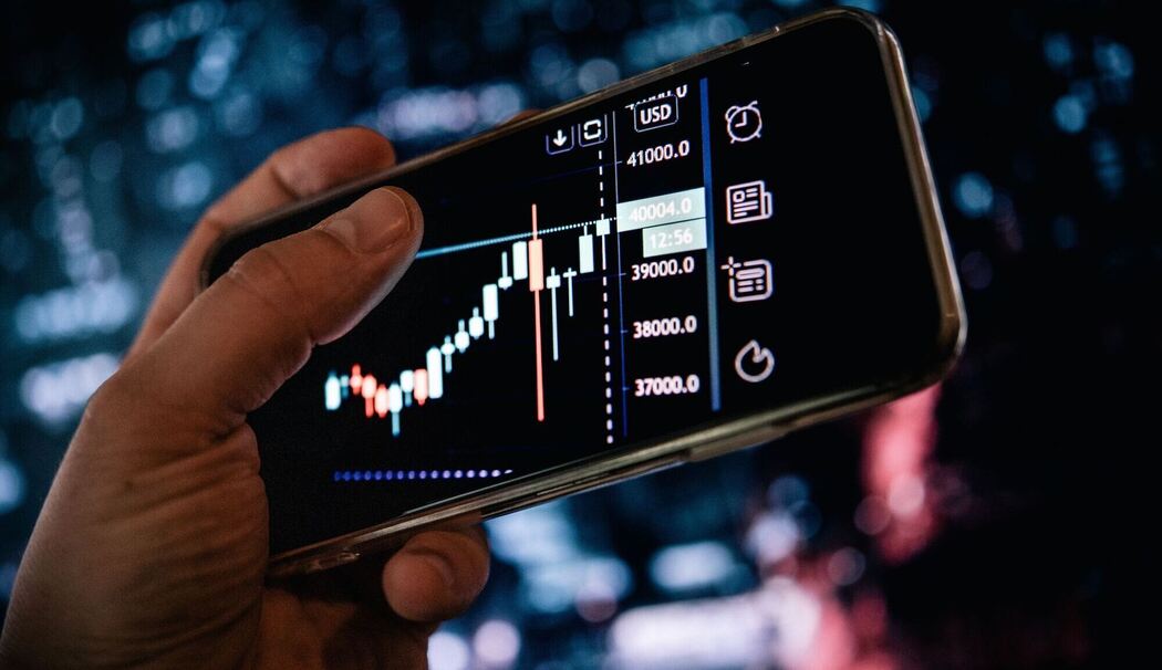Mann schaut sich Aktienkurse auf dem Smartphone an