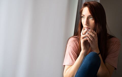 Frau schaut aus Fenster