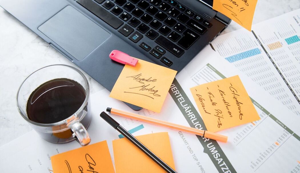 Chaos auf dem Schreibtisch mit Laptop, USB-Stick und Notizen Chaos auf dem Schreibtisch mit Laptop, USB-Stick und Notizen
