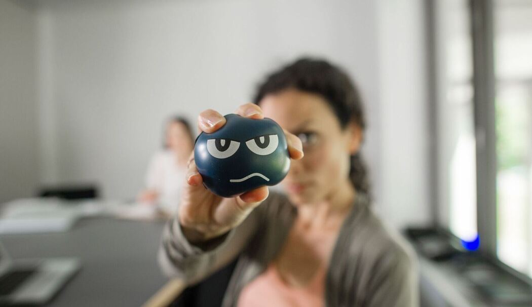 Eine Frau nutzt im Büro einen Anti-Aggressionsball