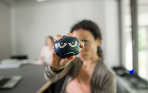 Eine Frau nutzt im Büro einen Anti-Aggressionsball