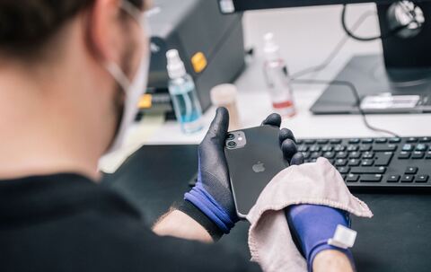 Ein Mitarbeiter überprüft ein refurbished Iphone