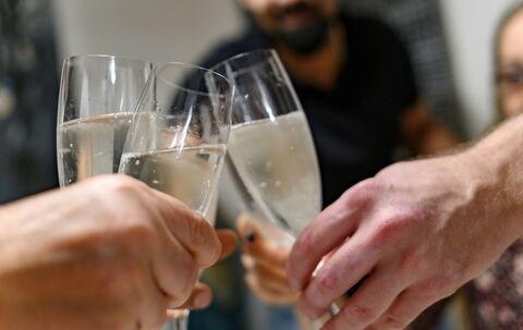 Mehrere Personen halten Sektgläser in den Händen