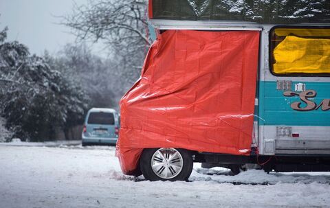 Eine Plane schützt die Fahrerkabine eines Wohnmobils